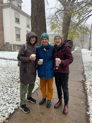 three friends smiling and holding coffee cups