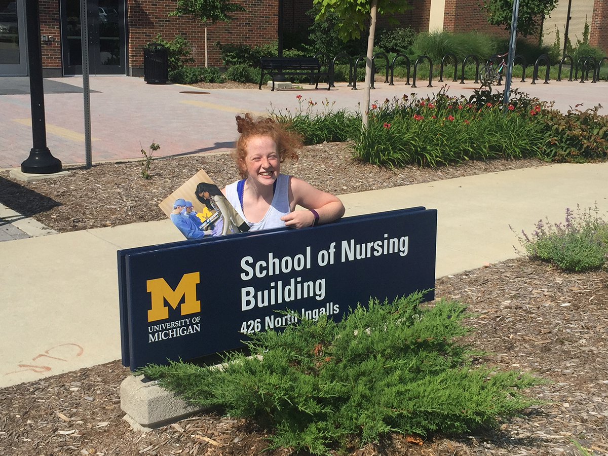 Ellie in front of the School of Nursing sign