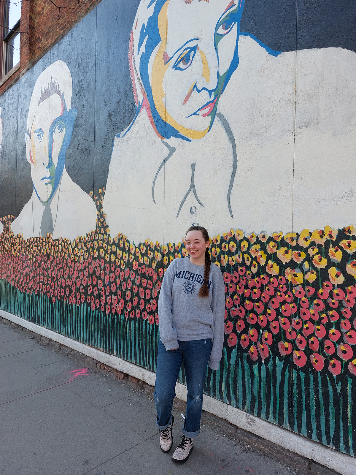 posing next to mural on corner of Liberty and State Street