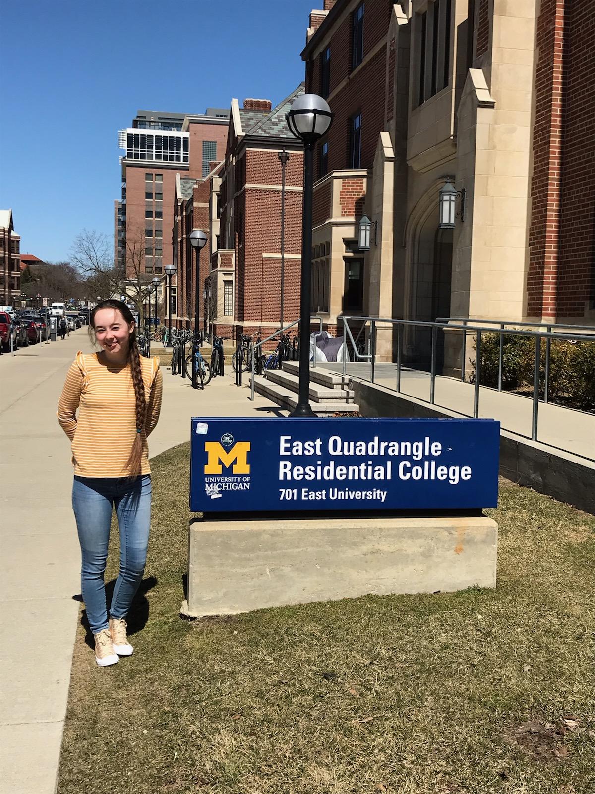 Standing next to East Quad Residential College sign