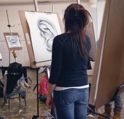 A student sketching at an easel