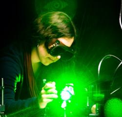 Student performing research in a lab with goggles