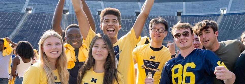 Group of students cheering at U-M football game 