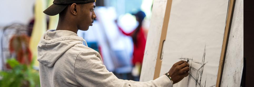 A student drawing at an easel