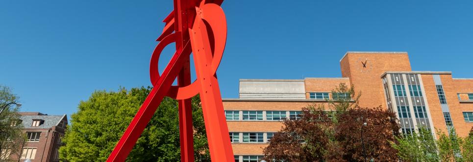 Bright red sculpture with LSA Building in the background