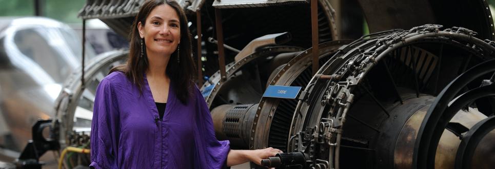 Woman posing next to a turbine