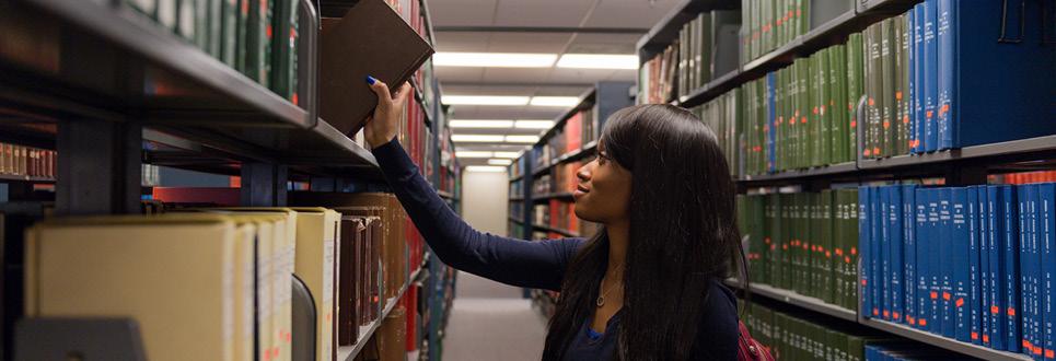 A student puts a book back on a shelf in the library