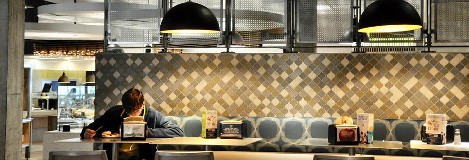 A male student studies in the dining hall