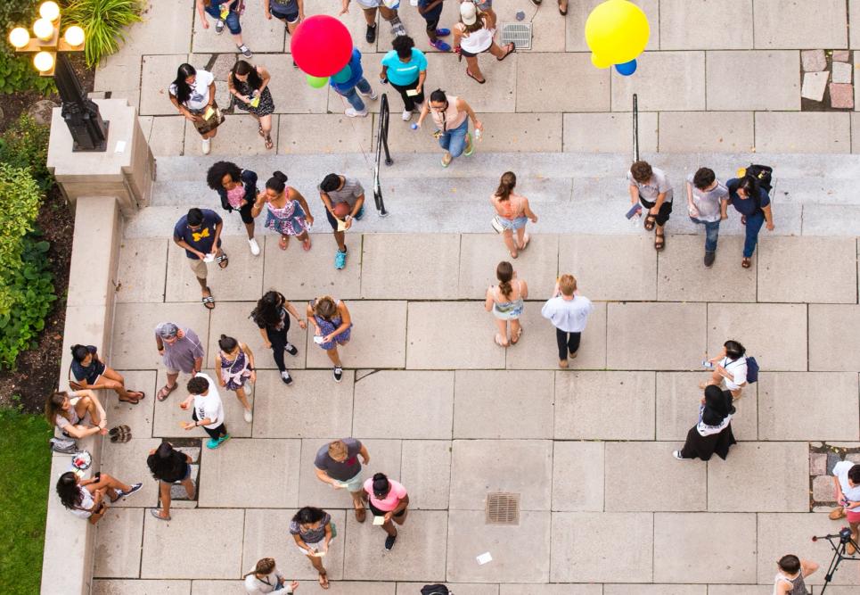 A red balloon amongst a crowd of students at a fair