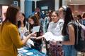 two students talking with a counselor at a financial aid fair